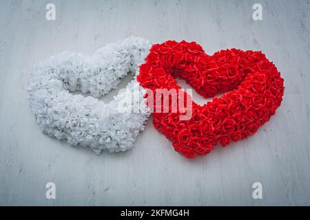 Two Hearts ist aus weißen und roten Flovern aus Rose auf grauem Hintergrund Valentinstag-Konzept Stockfoto