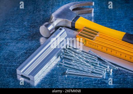 Holzmesser versuchen quadratische Edelstahl Nägel und Klauenhammer auf zerkratzte metallische Oberfläche Konstruktionskonzept. Stockfoto