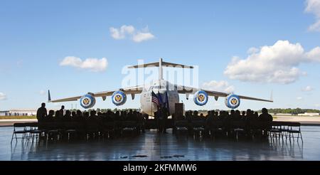 Ein C-17A Globemaster III bildet den Hintergrund für die Zeremonie des Air Mobility Wings 305. zur Verleihung des Chief of Staff des Air Force 2021 Exceptional Aviator Award auf der Joint Base McGuire-Dix-Lakehurst, N.J., 26. September 2022. Der CSAF 2021 Exceptional Aviator Award wurde an den US Air Force LT. Col. Eric Kut, 6. Airlift Squadron Chief of Group Standards and Evaluations, vom Order of the Daedalians für seine Tätigkeit als Flugzeugkommandeur der Mission REACH871 verliehen. Diese Mission führte zu der Bodenevakuierung von 823 afghanischen Zivilisten aus Kabul, während sie unter feindlichem Beschuss und stand Stockfoto