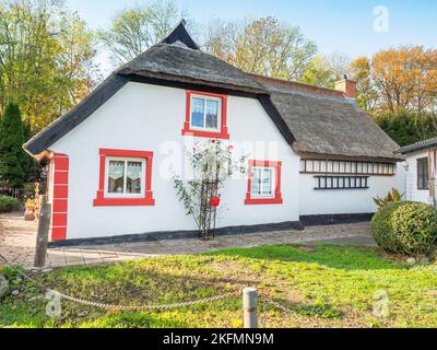 Buntes Haus mit Schilfdach im historischen Fischerdorf Vitt bei Kap Arkona, Deutschland Stockfoto