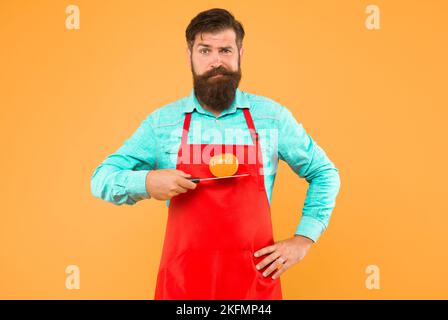 Ernährung und auch Ihr Körper verdient es. Bärtiger Mann hält Tomate auf dem Messer. Vegetarische Ernährung und Diät. Kochen für die Gesundheit. Ausgewogene Mahlzeit. Gesundes Menü Stockfoto