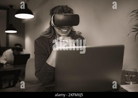 Geschäftsfrau arbeitet mit futuristischer Virtual Reality Brille im modernen Coworking Kreativraum - Technologie- und Innovationskonzept Stockfoto