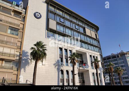 Ein niedriger Winkel eines Gebäudes der Handelskammer, das tagsüber von Palmen umgeben ist, in Izmir, Türkei Stockfoto