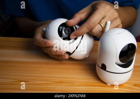 Konzeptioneller Mann mit IP-Kamera, weiße IP-Kameras, sehr beliebt für Sicherheitszwecke. Stockfoto