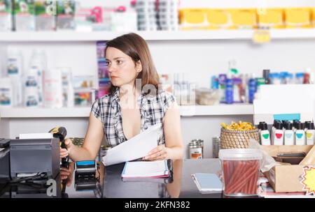 verkäufer arbeitet mit Dokumenten und Waren im Tiergeschäft Stockfoto