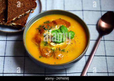 Kürbiskarottensuppe mit Fleischbällchen in einer Schüssel. Herbstmenü. Stockfoto