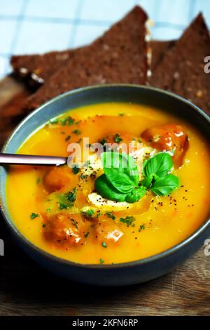 Kürbiskarottensuppe mit Fleischbällchen in einer Schüssel. Herbstmenü. Stockfoto