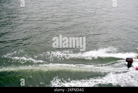 Wellen von einem vorbeifahrenden Boot im See. Heckenwelle vom Schnellboot. Seitenansicht Stockfoto