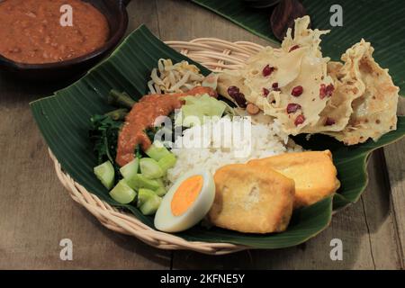 Nasi Pecel Madiun, Indonesien Essen Reis und Gemüse mit gekochtem Ei und Erdnusssauce Stockfoto