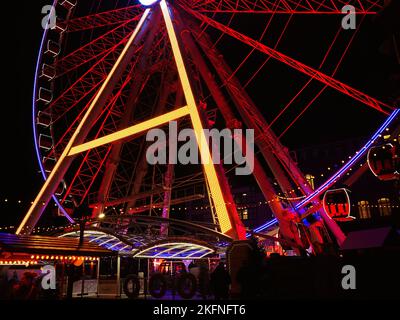 Nahaufnahme des beleuchteten Riesenrads auf dem Weihnachtsmarkt 2022 am Burgplatz in der Düsseldorfer Altstadt. Stockfoto