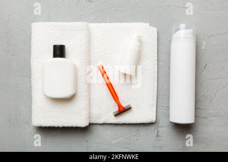 Rasierer-Set. Schermaschine, Handtuch, Lotion und Rasierschaum auf farbigem Hintergrund. Herren Bad Accessoires Draufsicht. Stockfoto