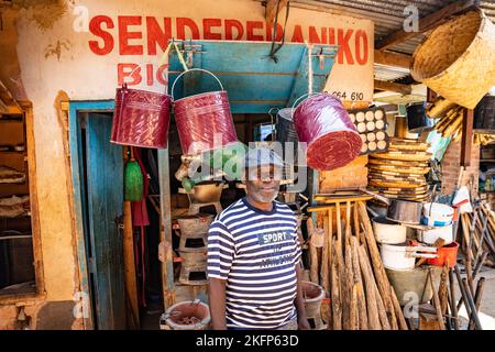 Ein Mann steht vor seinem Eisenwarenladen in Mzuzu Markt, Malawi Stockfoto