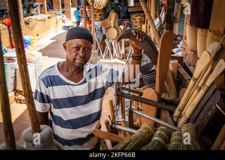 Ein Mann steht neben seinem Eisenwarenladen auf dem Markt in Mzuzu, Malawi Stockfoto