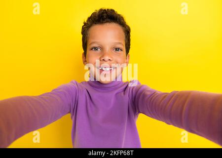 Foto von positiven freundlichen Schulkind machen Selfie strahlend Lächeln isoliert auf gelbem Hintergrund Stockfoto