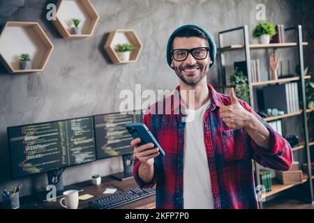 Foto von lustigen selbstbewussten Kerl gekleidet Brillen Bewertung twitter-Telegramm facebook-Apps modernes Gerät im Innenbereich Workstation-Werkstatt zu Hause Stockfoto