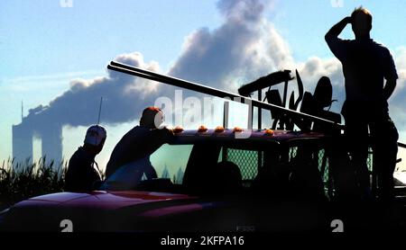 Bauarbeiter bauen einen Zaun entlang der St. RT. 6 in der Nähe von Newark, NJ, stoppen Sie alles, um das World Trade Center in der Ferne brennen zu sehen. Viele wor Stockfoto
