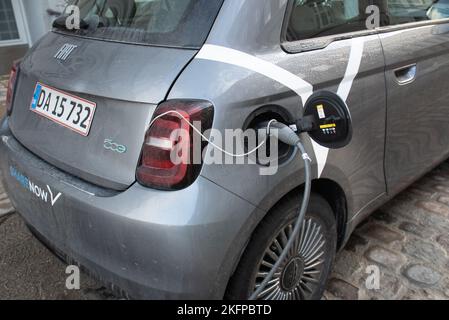 Aufladen von Elektroautos: Ein Fiat 500-Auto, das seine Batterie an einer Ladestation in Kopenhagen, Dänemark, Europa auflädt. Nachhaltiger Verkehr. Stockfoto