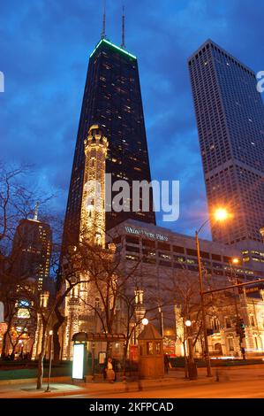 Der Historic Water Tower, einer der wenigen Survivors des Chicago Fire, befindet sich bei Nacht zwischen den modernen Wolkenkratzern entlang der Michigan Avenue Stockfoto