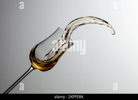 Das Getränk wird aus dem Glas verschüttet. Konzept des Themas Premium-Alkohol. Speicherplatz kopieren. Stockfoto