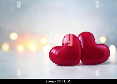 Zwei rosa Valentinstag Herz auf pastellfarbenem glittergrauem Hintergrund. Liebeskonzept, Blick von oben. Minimalistischer Hipster-Style. Stockfoto