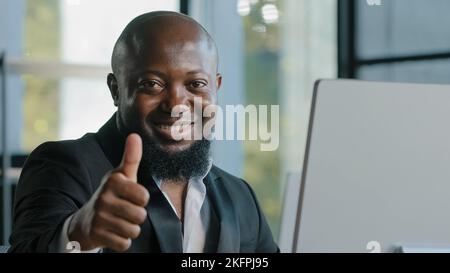 Afrikanischer Erwachsener Geschäftsmann glücklich plus Größe Kerl zufrieden mit Computer-App-Eingabe auf Laptop im Büro lächelnd empfehlen gute Wahl feine Idee Zeichen Stockfoto