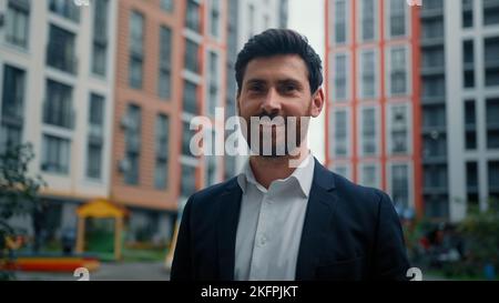 Verträumt männlich Geschäftsmann schöner bärtig kaukasisch 40s Mann Business Person posiert auf Stadt Straße stehen im Freien positiv lächelnd Millennial Kerl reich Stockfoto