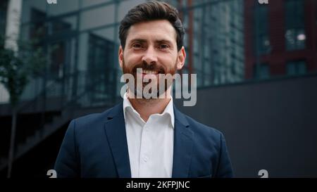 Schöner Mann kaukasischen bärtigen 40s Geschäftsmann Führer Chef erfolgreiche männliche Unternehmer glücklich erwachsenen Millennial Kerl stehen in der Stadt außerhalb modern Stockfoto