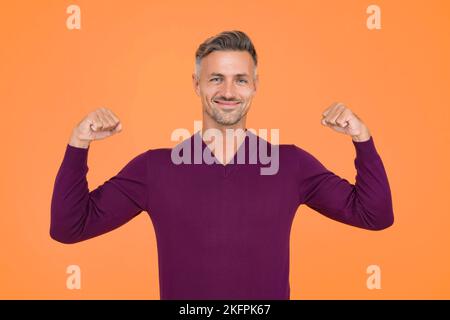 Vertrauen ist das beste Outfit. Selbstbewusster Mann, gelber Hintergrund. Schöner Kerl Flex Arme. Selbstbewusster Look des Models. Mode und Style. Selbstbewusst und Stockfoto