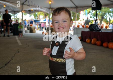 Der zweijährige Jack MacFarland zeigt sein Outfit, während er zur Oompah Band auf dem Oktoberfest in Fort Leavenworth tanzt Stockfoto