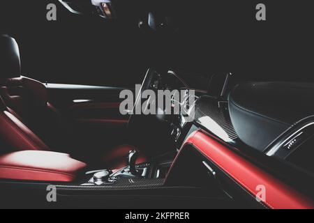 Luxuswagen im Inneren. Interieur von Prestige modernen Auto. Bequeme Ledersitze. Rotes, perforiertes Ledercockpit. Stockfoto