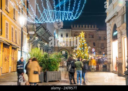 Das Gebäude der Comune di Parma und der Weihnachtsbaum in Parma bei Nacht. Verschwommene Bewegung von Menschen und vielleicht Studenten (nicht erkennbar) - erstaunlich! - Ne Stockfoto