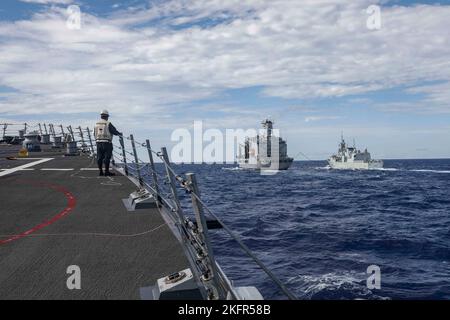 SÜDCHINESISCHES MEER (OKT 2, 2022) Arleigh Burke-Klasse Lenkraketen-Zerstörer USS Higgins (DDG 76), links, nähert sich Henry J. Kaiser-Klasse unterwegs Nachschuböler USNS Rappahannock (T-AO 204), Mitte, während er eine Nachschubflotte auf See mit der Royal Canadian Navy Halifax-Klasse Fregatte HMCS Windpeg (FFH 338) im Südchinesischen Meer, Oktober 2, durchführt. Higgins nimmt an multilateralen Übungen im Südchinesischen Meer zur Unterstützung des Indo-Pazifik-Einsatzes der japanischen Maritime Self-Defense Force zusammen mit der Royal Canadian Navy Teil. Routinemäßige multilaterale Übungen wie diese stärken die Interoperabilität Stockfoto