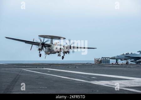 221003-N-LI114-2092 PAZIFISCHER OZEAN (OKT 3, 2022) eine E-2D Hawkeye, die an den Tiger Tails of Airborne Early Warning Squadron (VAW) 125 befestigt ist, steigt für eine Landung auf dem Flugdeck des einzigen vorwärts eingesetzten Flugzeugträgers der US Navy, USS Ronald Reagan (CVN 76), im Pazifischen Ozean, am 3. Oktober herab. E-2D Hawkeyes führen taktische Flugwarnmissionen durch, um der Carrier Strike Group (CSG) 5 bei der Planung und Durchführung von Operationen wertvolle Informationen zu liefern. Ronald Reagan, das Flaggschiff der CSG 5, stellt eine kampfbereite Truppe bereit, die die Vereinigten Staaten schützt und verteidigt, und unterstützt Allianzen, Stockfoto