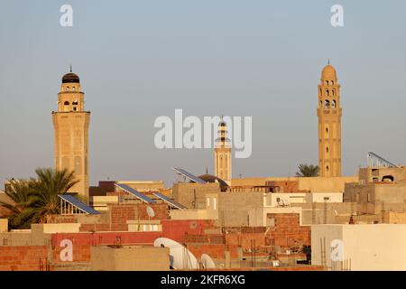 Stadtansicht der Stadt Tozeur in Tunesien bei Sonnenuntergang mit Minaretten einer Moschee im Hintergrund. Medina von Tozeur, Altstadt. Ort der Geschichte. Stockfoto