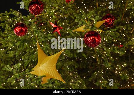 Selektive Fokusansicht des goldenen Dekorationssterns auf dem Weihnachtsmarkt am Weihnachtsbaum, weihnachtsmarkt. Stockfoto
