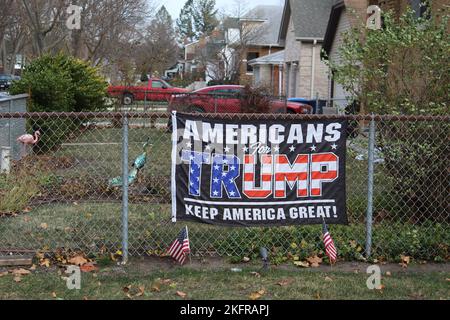 Amerikaner für Trump halten Amerika ein großartiges Banner auf einem Zaun mit Fahnen und einem rosa Flamingo in des Plaines, Illinois Stockfoto