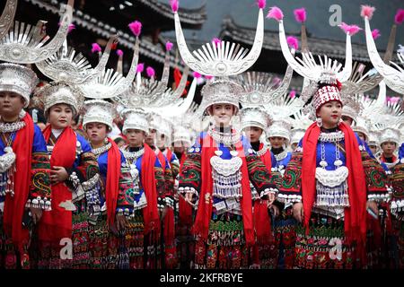 QIANDONGNAN, CHINA - 19. NOVEMBER 2022 - Menschen der ethnischen Gruppe Miao in ihren festlichen Kostümen führen den traditionellen Lusheng-Tanz in Qiandongna auf Stockfoto