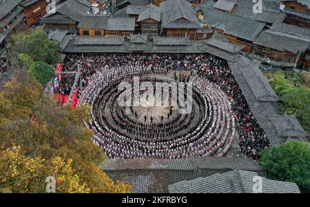 QIANDONGNAN, CHINA - 19. NOVEMBER 2022 - Menschen der ethnischen Gruppe Miao in ihren festlichen Kostümen führen den traditionellen Lusheng-Tanz in Qiandongna auf Stockfoto