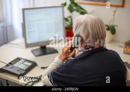 Halle, Deutschland. 15.. November 2022. Ulrike Hänel, Mitarbeiterin der Telefonberatung in Halle (Saale), sitzt an ihrem Schreibtisch. Corona, Krieg und Inflation haben auch die Zahl der Menschen erhöht, die Hilfe bei der Telefonberatung suchen. In Sachsen-Anhalt gibt es manchmal Wartezeiten. Die Themen konzentrieren sich nun mehr auf existenzielle Angst wegen der Kostenexplosion und Corona. (To dpa: 'Telefonberatung: Mehr Anrufer mit Angst vor Krisen') Kredit: Jan Woitas/dpa/Alamy Live News Stockfoto