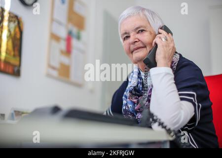 Halle, Deutschland. 15.. November 2022. Ulrike Hänel, Mitarbeiterin der Telefonberatung in Halle (Saale), sitzt an ihrem Schreibtisch. Corona, Krieg und Inflation haben auch die Zahl der Menschen erhöht, die Hilfe bei der Telefonberatung suchen. In Sachsen-Anhalt gibt es manchmal Wartezeiten. Die Themen konzentrieren sich nun mehr auf existenzielle Angst wegen der Kostenexplosion und Corona. (To dpa: 'Telefonberatung: Mehr Anrufer mit Angst vor Krisen') Kredit: Jan Woitas/dpa/Alamy Live News Stockfoto