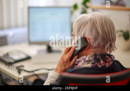 Halle, Deutschland. 15.. November 2022. Ulrike Hänel, Mitarbeiterin der Telefonberatung in Halle (Saale), sitzt an ihrem Schreibtisch. Corona, Krieg und Inflation haben auch die Zahl der Menschen erhöht, die Hilfe bei der Telefonberatung suchen. In Sachsen-Anhalt gibt es manchmal Wartezeiten. Die Themen konzentrieren sich nun mehr auf existenzielle Angst wegen der Kostenexplosion und Corona. (To dpa: 'Telefonberatung: Mehr Anrufer mit Angst vor Krisen') Kredit: Jan Woitas/dpa/Alamy Live News Stockfoto