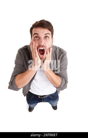 Schock und Schrecken. High-Angle-Aufnahme eines jungen Mannes im Studio, der vor Entsetzen schreit. Stockfoto