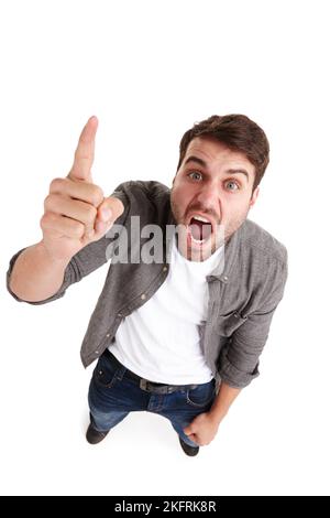 Wenn Ihre Mitarbeiter so aussehen, brauchen Sie Hilfe. Hochwinkelporträt eines wütenden jungen Mannes im Studio, der seinen Finger schüttelt und schreit. Stockfoto