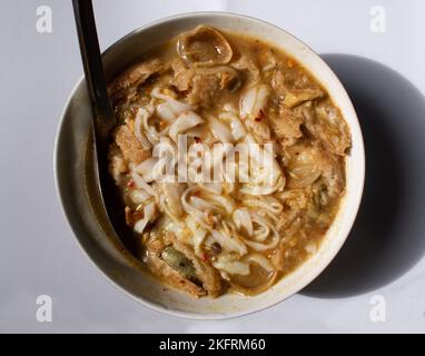 Myanmar traditionelle oder klassische weiße flache Nudelfischsuppe namens Khauk SWE. Nahaufnahme. Stockfoto