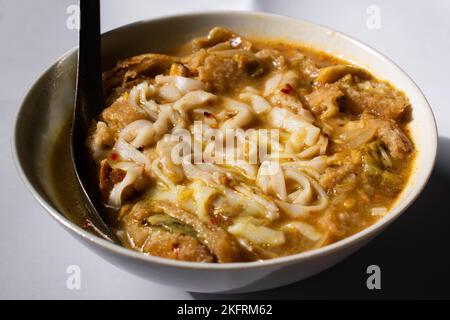 Myanmar traditionelle oder klassische weiße flache Nudelfischsuppe namens Khauk SWE. Nahaufnahme. Stockfoto