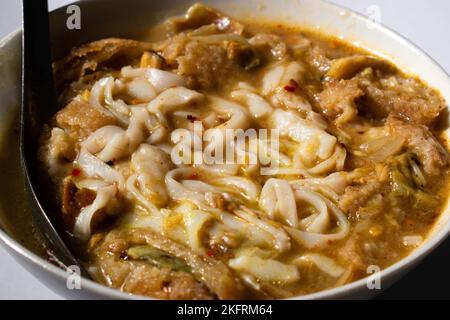 Myanmar traditionelle oder klassische weiße flache Nudelfischsuppe namens Khauk SWE. Nahaufnahme. Stockfoto