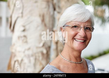 Vertrauen ist die Fähigkeit, sich schön zu fühlen. Porträt einer lächelnden älteren Frau. Stockfoto