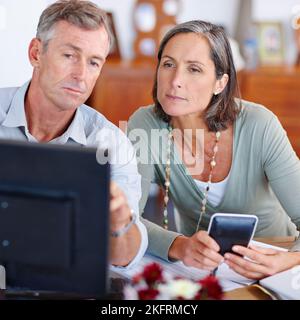 Überprüfung ihres Budgets. Ein reifes Ehepaar geht durch ihre Finanzen zu Hause. Stockfoto