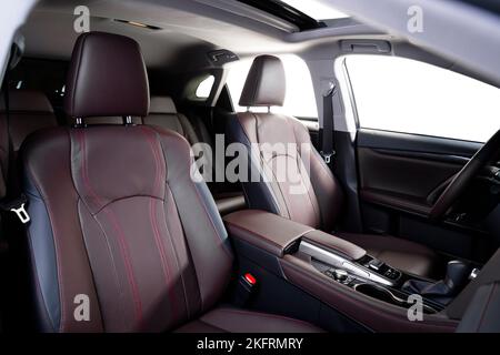 Luxuswagen im Inneren. Interieur von Prestige modernen Auto. Bequeme Ledersitze. Rotes, perforiertes Ledercockpit. Stockfoto