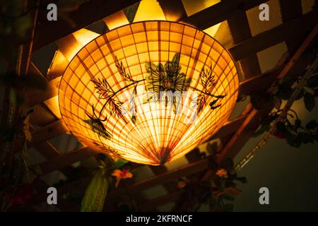 Deckenlaterne aus Bambusgewebe im traditionellen asiatischen Stil. Chinesische Laternen während des Neujahrsfestes, in Farbtönen. Niemand, selektiver Fokus Stockfoto